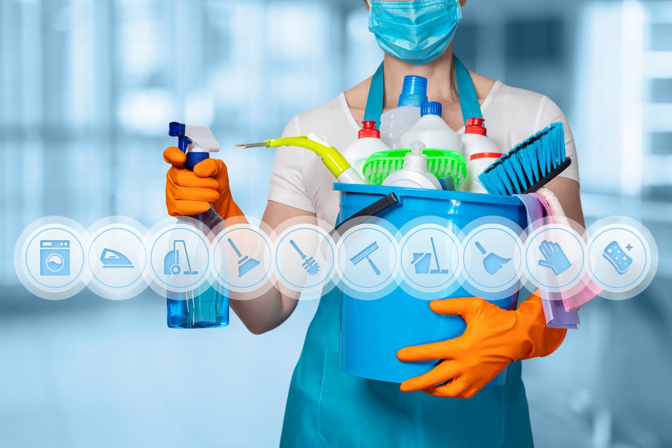 Cleaning lady with cleaning products on blurry background .